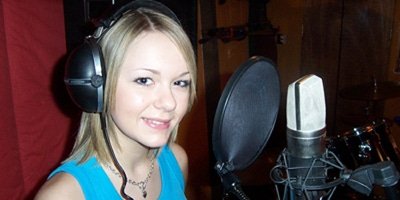 Girl singing into a professional microphone on a studio experience day session.
